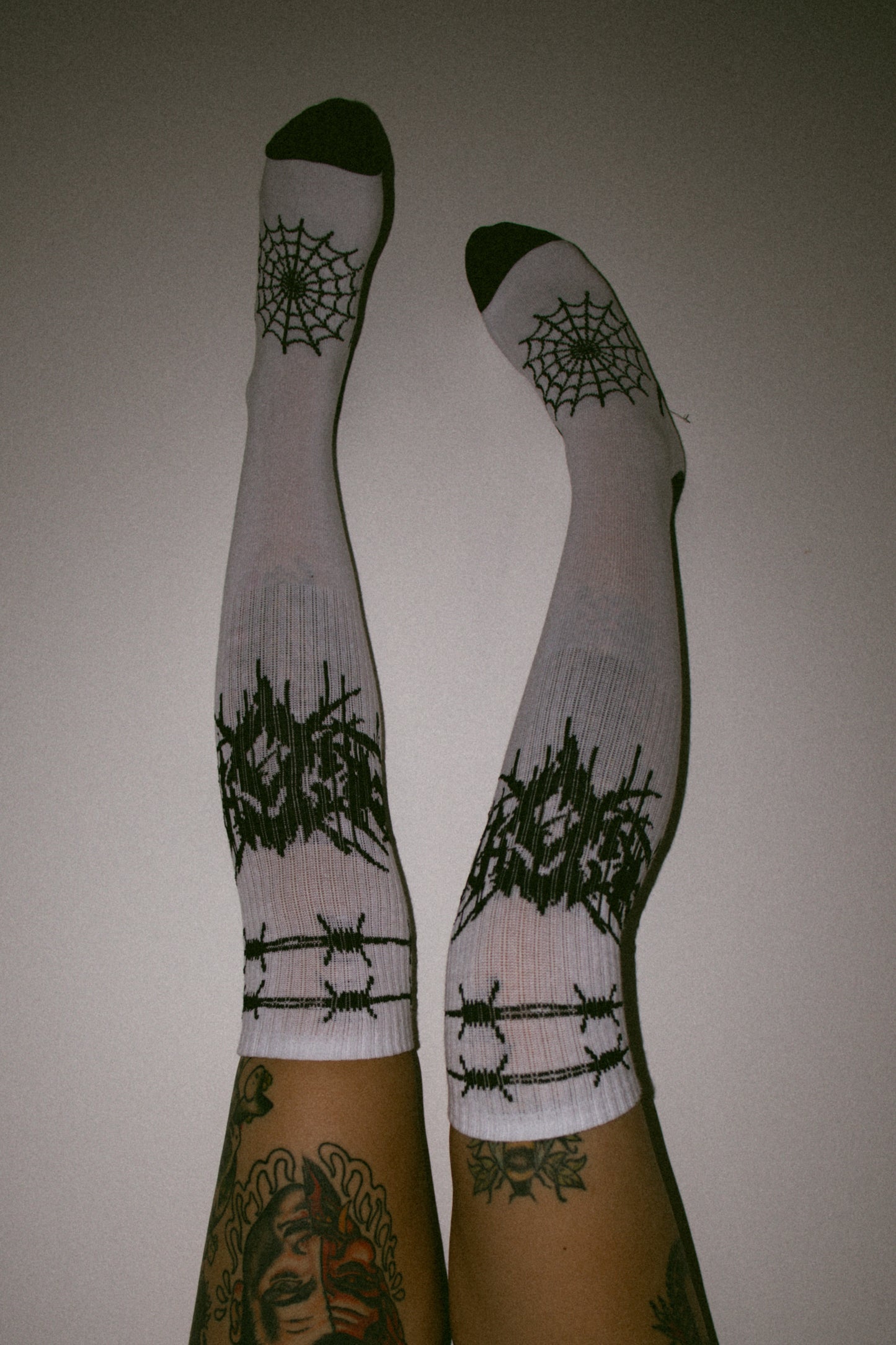 Eightysix and OG socks metal knee high socks in white worn by tattoo streetwear model