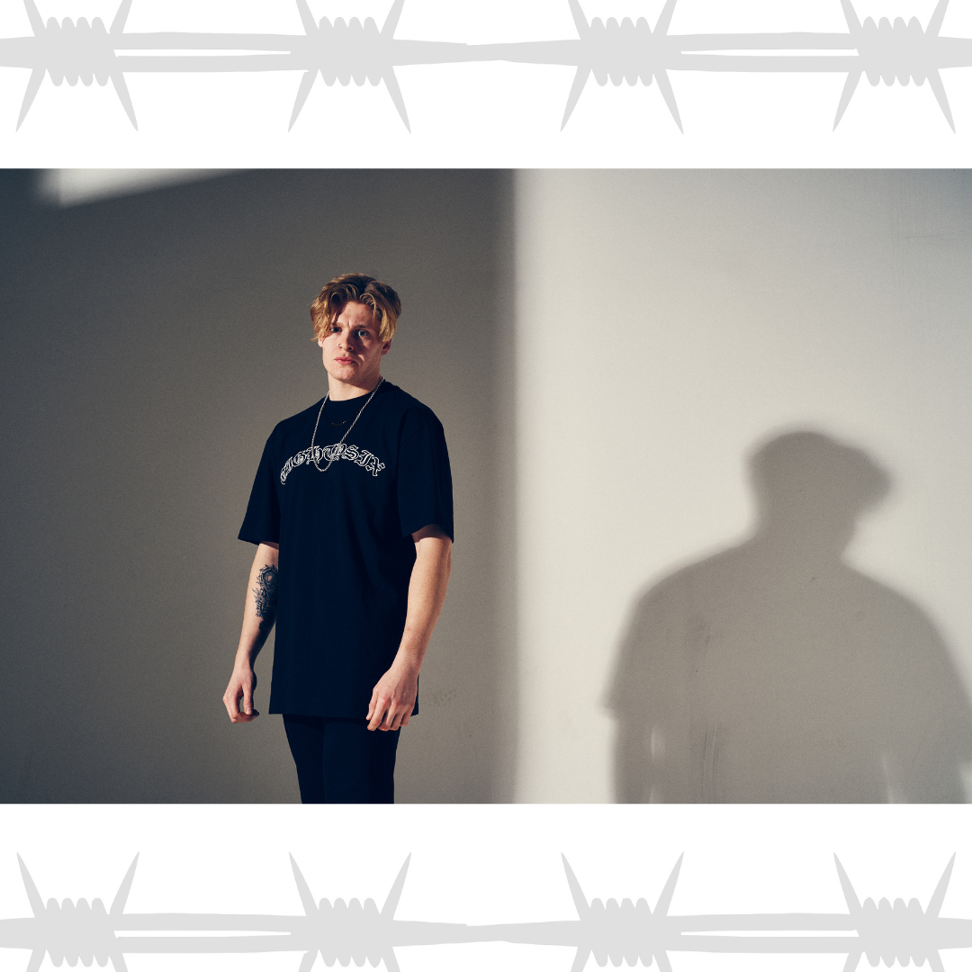 Old English tattoo script t-shirt in black worn by an alternative tattooed model
