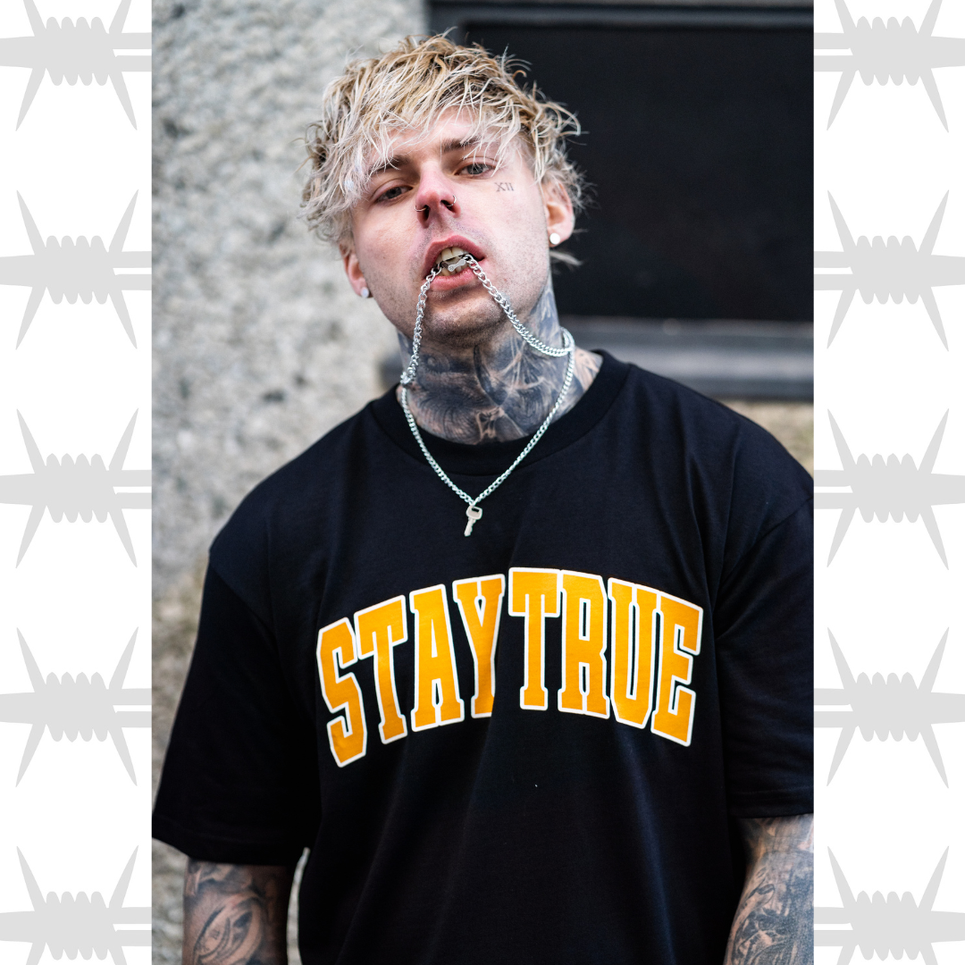 Stay true varsity graphic tee in black worn by alternative tattoo model