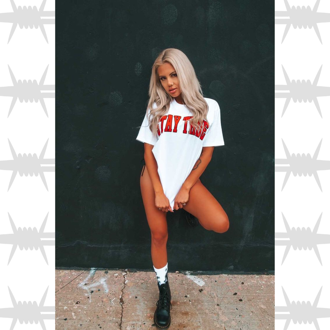 Stay True Varsity graphic t-shirt in white with orange stay true worn bu tattooed alternative lifestyle model