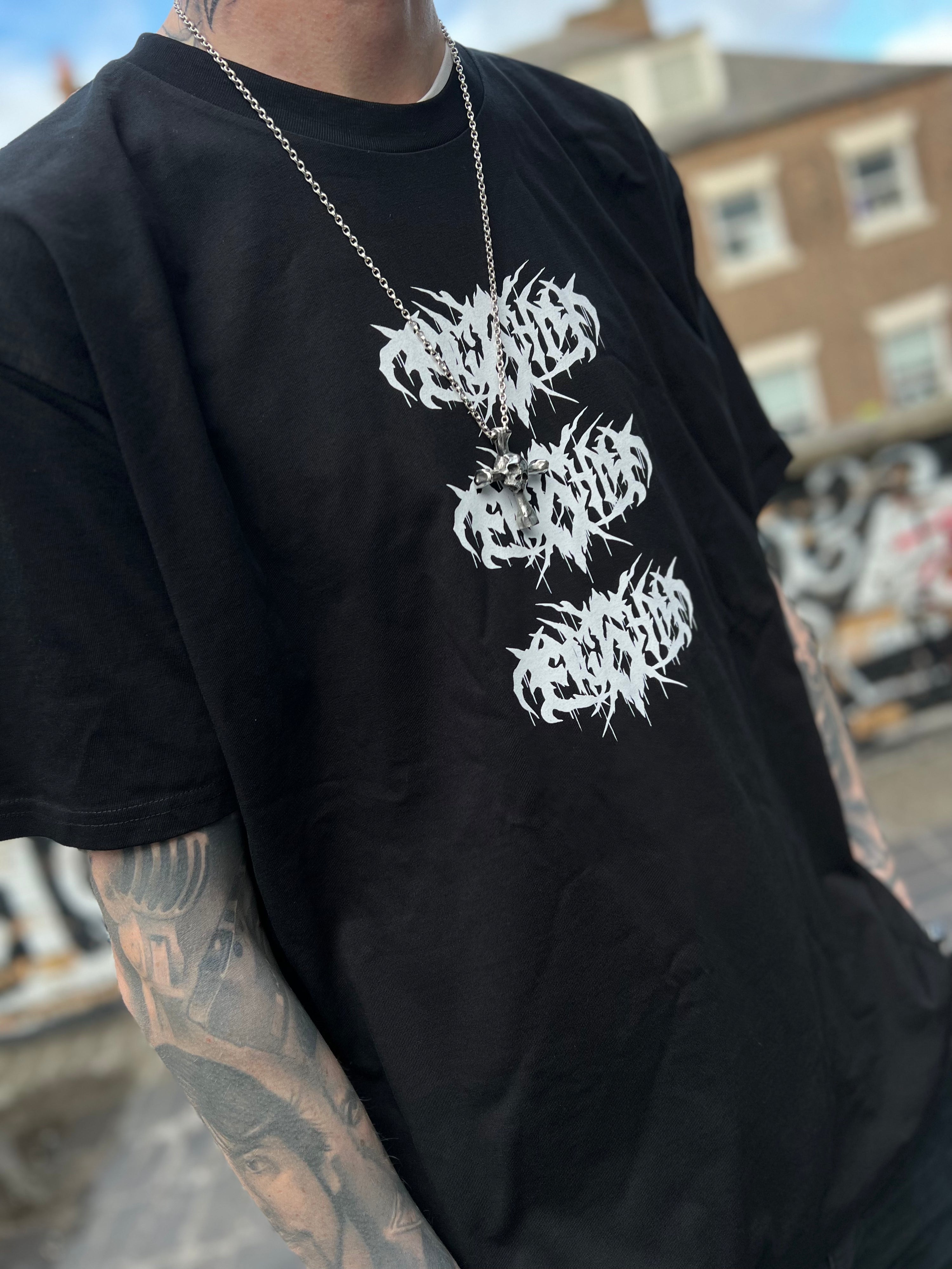 Death metal t-shirt as worn by a tattoed model, the design features a triple stacked grunge script style Eightysix logo in the centre of the t-shirt