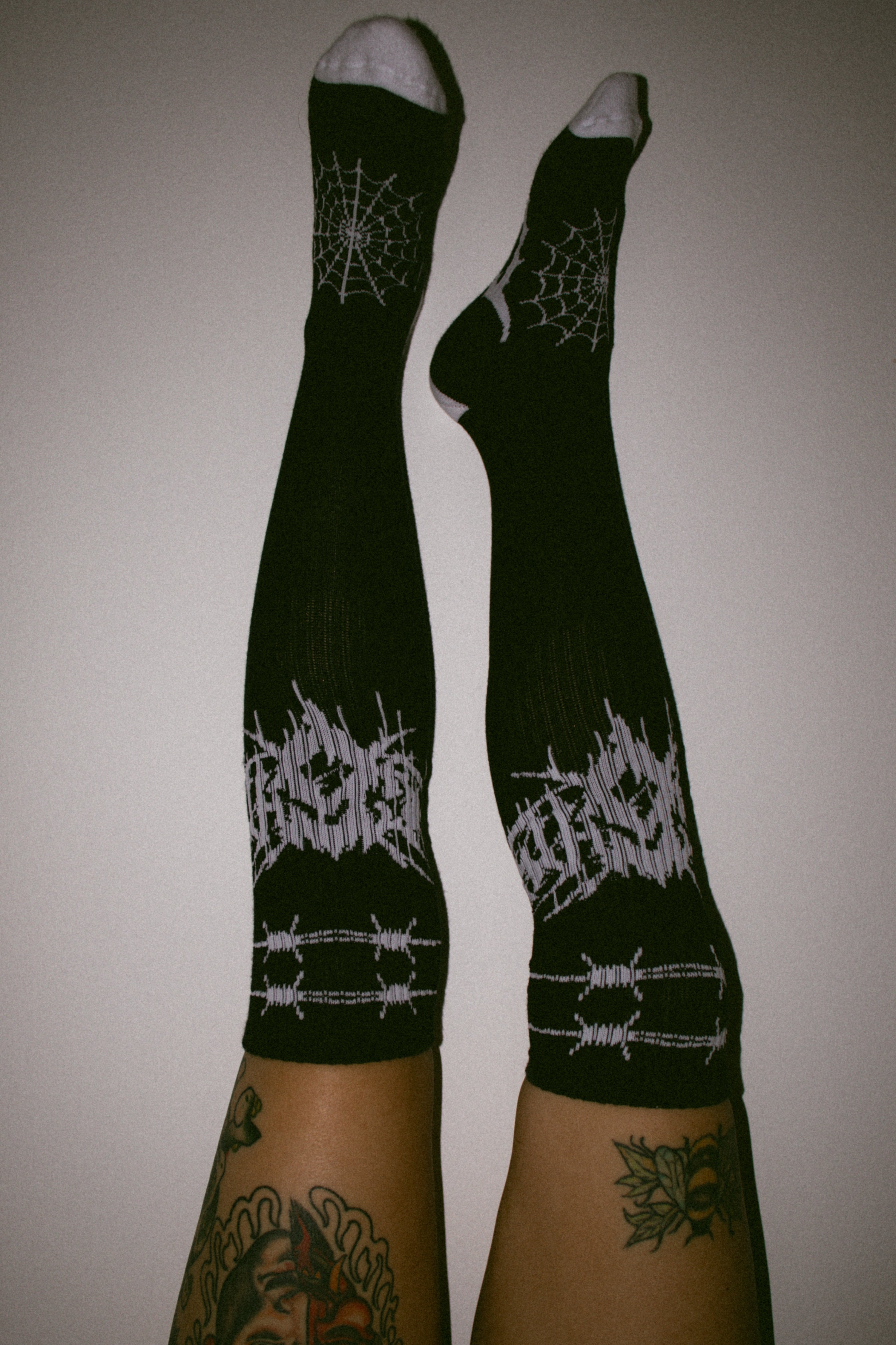 Eightysix og socks collaberation metal knee high socks worn by a tattooed alternative lifestyle model