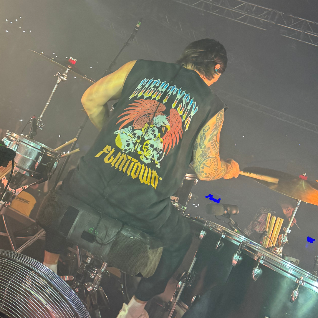 eightysix x flinttown tank from the back worn by the drumer from the band you me at six while playing drums at a live gig