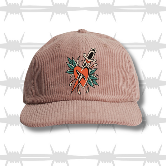 hazy pink cord cap with traditional tattoo style heart and dagger design