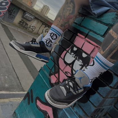 White og sock with two blue stripes and OG logo written in old english worn by model