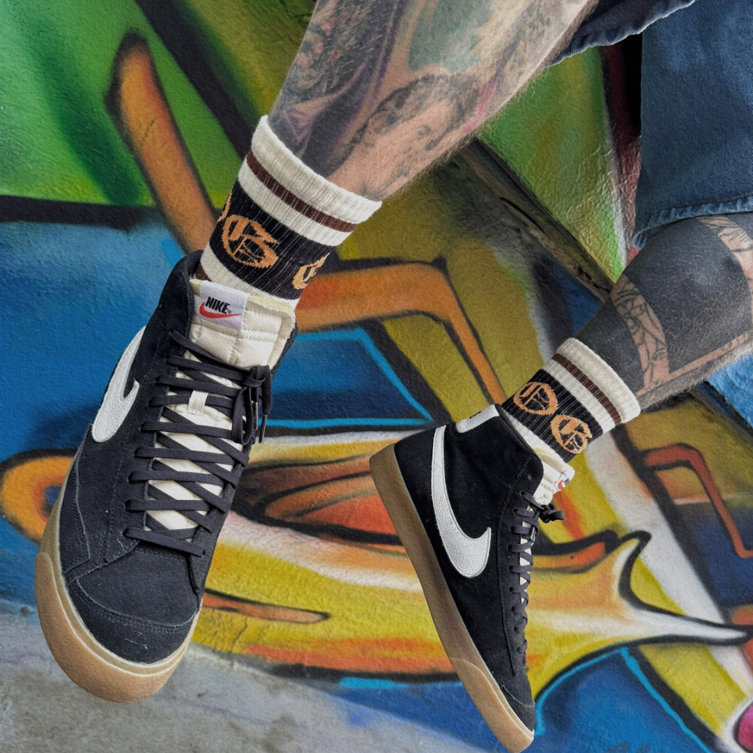 White OG socks with two espresso stripes and a black band with an orange OG logo worn by model