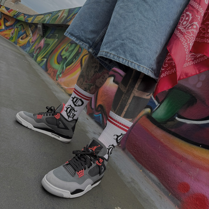 White OG socks with OG writen in old english and two red stripes worn by tattooed model