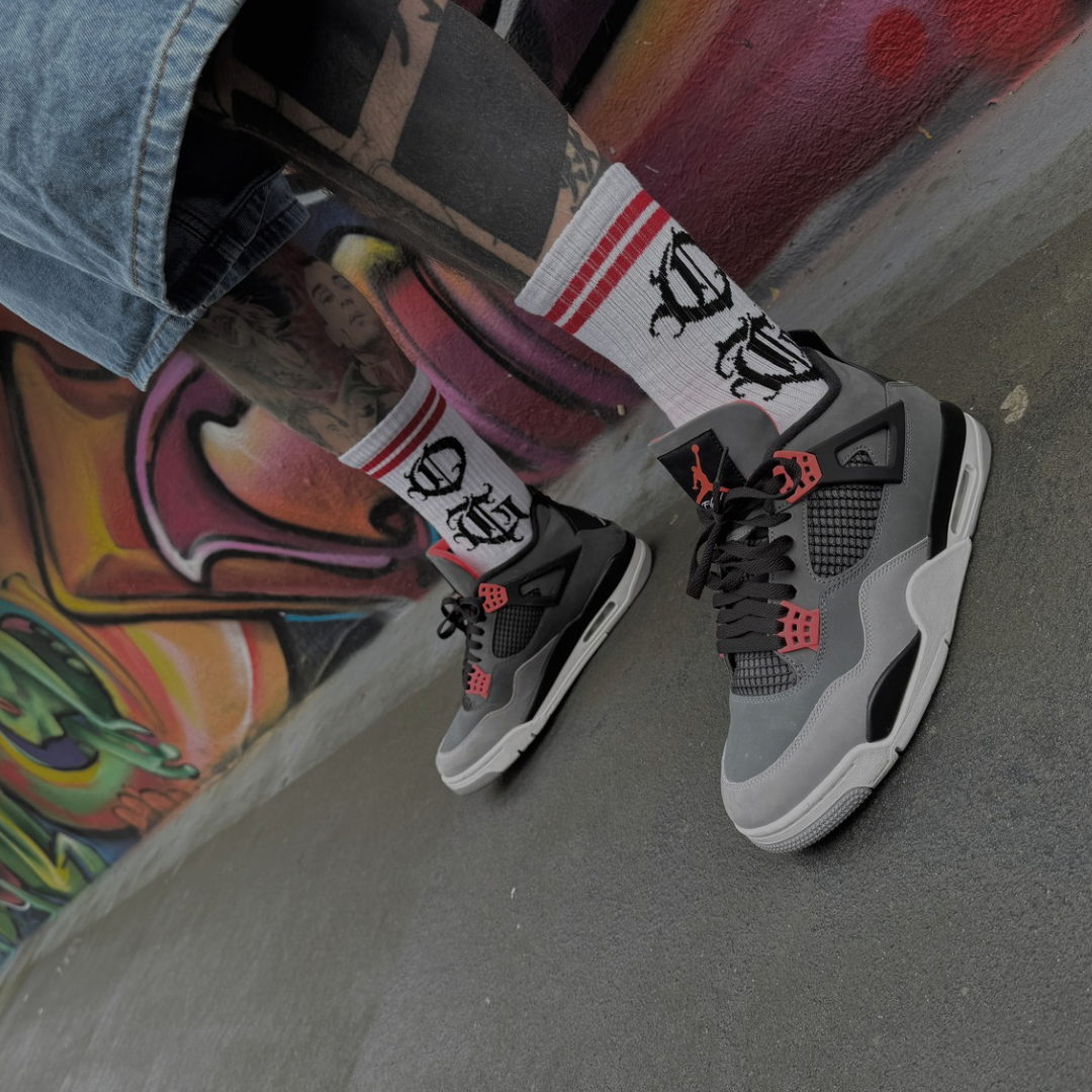 White OG socks with OG writen in old english and two red stripes worn by tattooed model