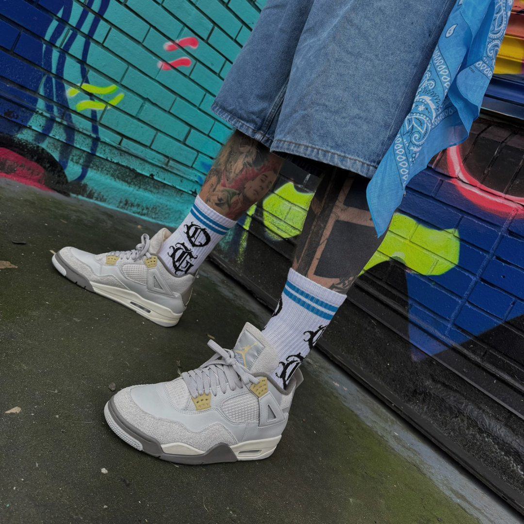 White og sock with two blue stripes and OG logo written in old english worn by model