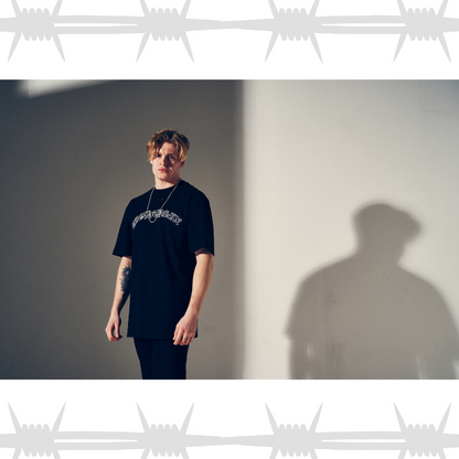 Old English tattoo script t-shirt in black worn by an alternative tattooed model