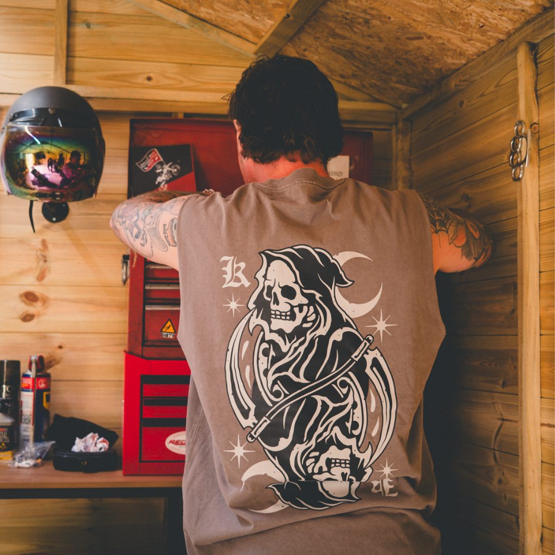 model wearing reaper tank top in grey while working in a workshop