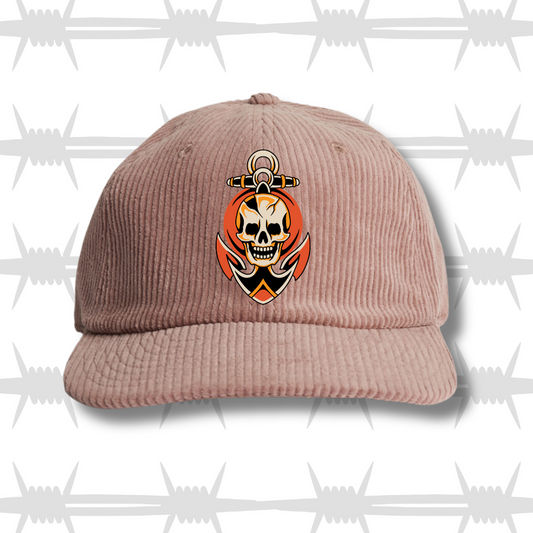 hazy pink cord cap with a traditional tattoo style skull and anchor design
