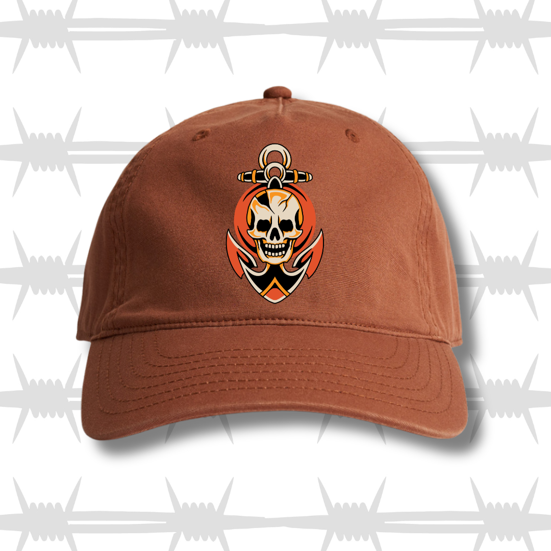 clay coloured dad cap with traditional tattoo style skull and anchor design