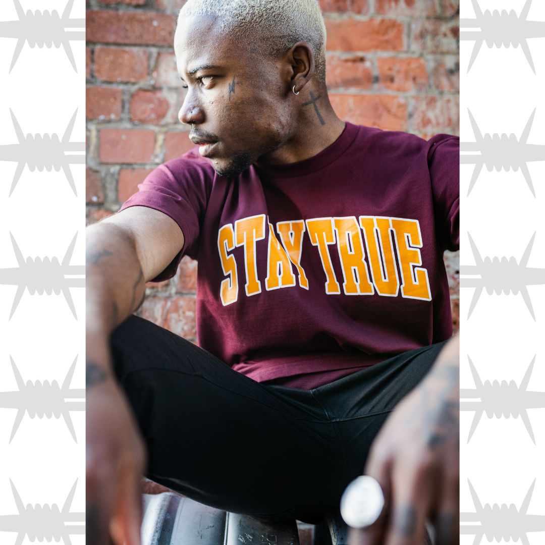 Stay true varsity t-shirt in burgundy worn by tattooed alternative lifestyle streetwear model