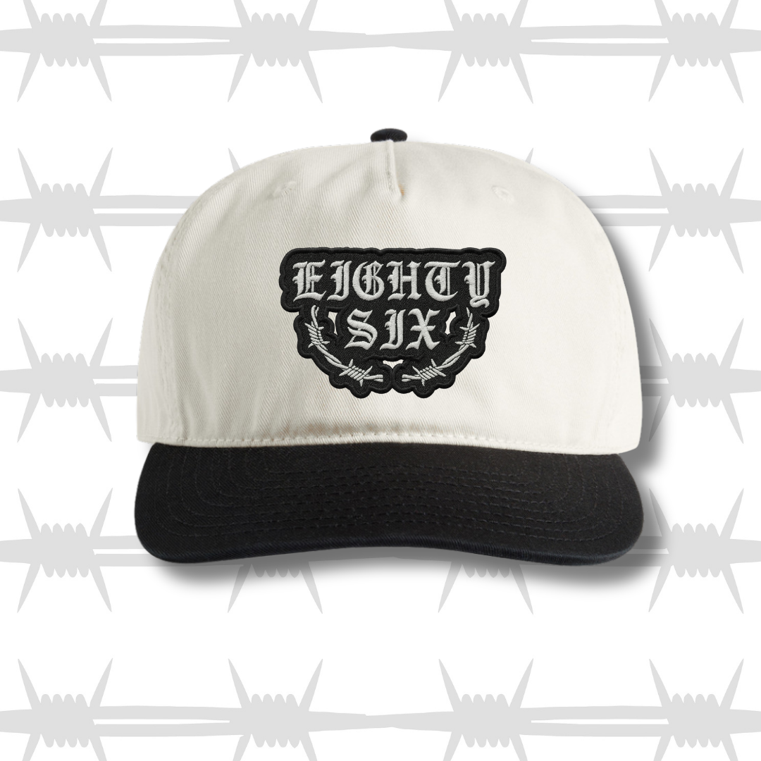 Two tone black and white cap with embroidered eightysix logo with a barbed wire accent front shot