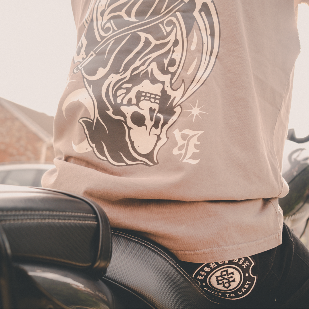 Model image of biker wearing the grey reaper tank top and ES trousers while riding a harley